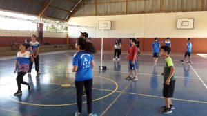 Alunos do projeto Vôlei em Rede auxiliam convidados durante atividades.